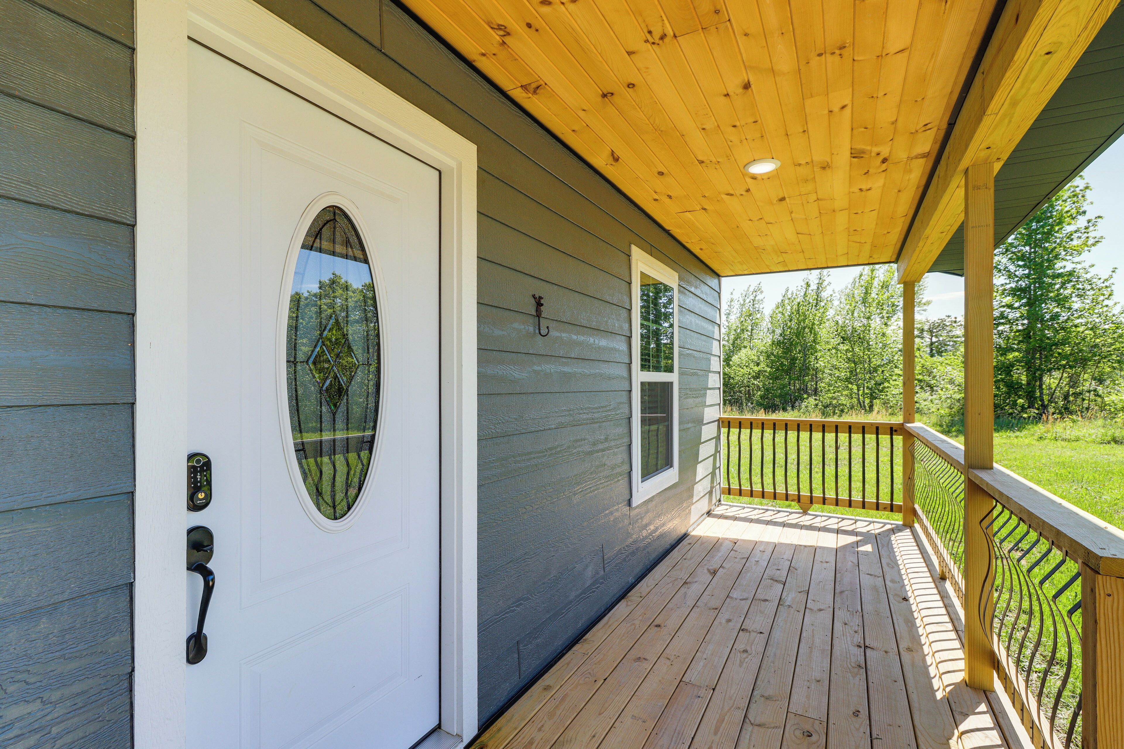 Un patio in legno con una porta bianca e una finestra.
