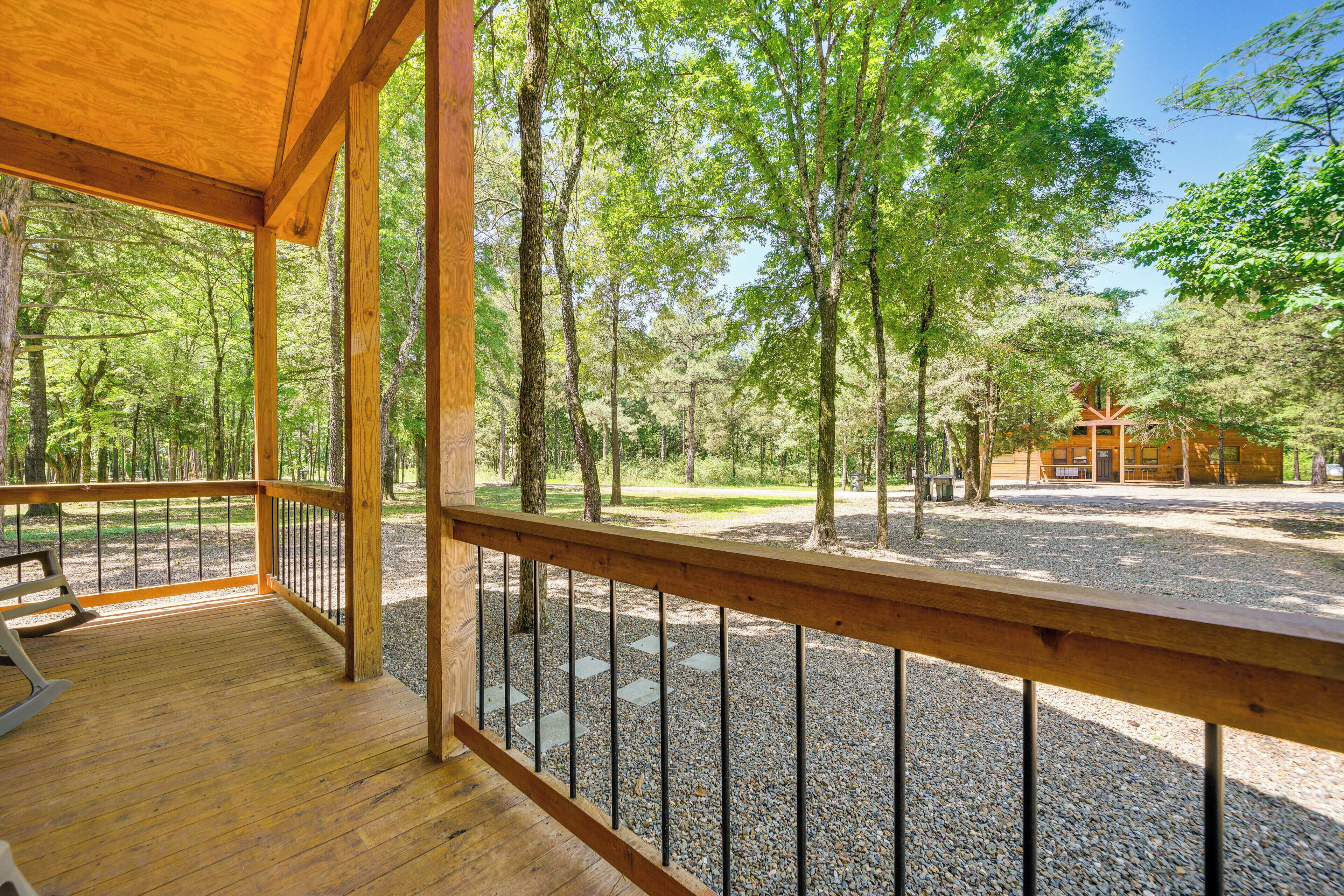 A wooden deck with a gravel path leading to a cabin.
