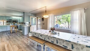 A kitchen with wooden flooring, a dining table with a tablecloth, and a bench. - Beautiful Kernville Home w/ Game Room & Mtn Views! (Kernville)