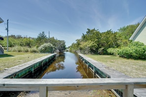 A narrow water channel flanked by wooden walkways and greenery. - Buxton Apartment ~ 2 Mi to Lighthouse Beach! (Buxton)