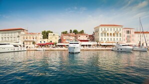 A marina with several yachts docked, surrounded by historic buildings with red-tiled roofs and white facades. - Sophia near Porec big private Garden (Nova Vas)