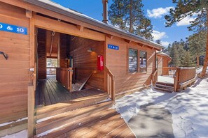 A wooden cabin with a ramp leading to the entrance, a fire extinguisher mounted on the wall, and a sign indicating room numbers 17 & 12.