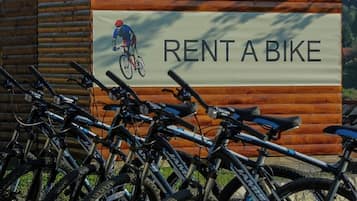 Una fila de bicicletas estacionadas frente a un edificio con un letrero que dice 'RENT A BIKE'.
