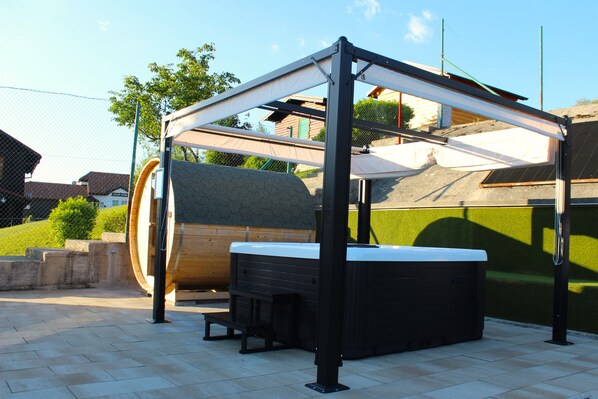 Un jacuzzi bajo una estructura de pérgola en un entorno exterior.