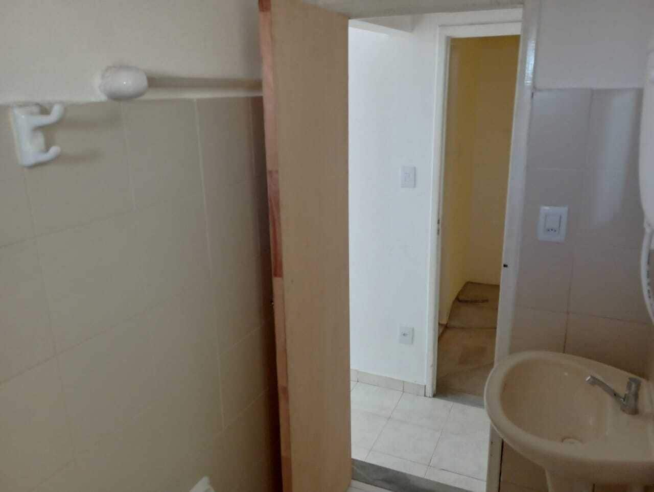A bathroom with a sink, a mirror, and a door leading to another room.