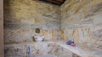 A bathroom with marble walls and a bench.