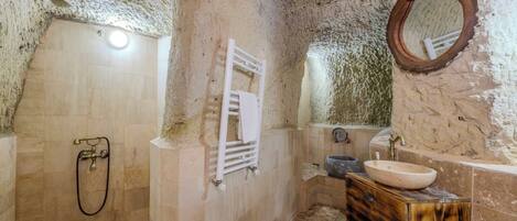 A bathroom with a shower, a sink, and a mirror.