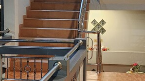 A staircase leading to an upper floor, a fire extinguisher on the wall, and a small decorative plant.