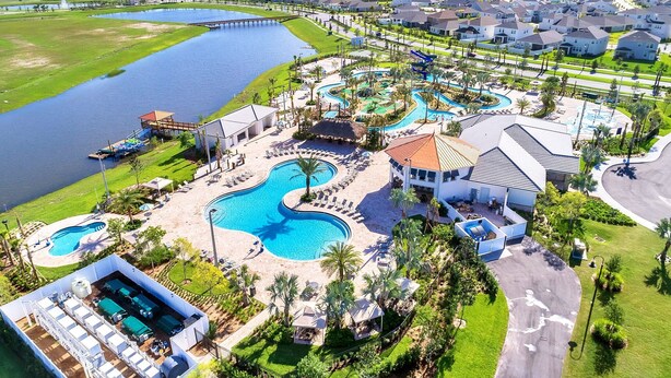 Ein Resort mit mehreren Schwimmbecken, einem Steg und einem Wohngebiet mit Häusern.