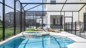 Ein Swimmingpool mit Liegestühlen und einem Whirlpool, umgeben von einer Glaskonstruktion.