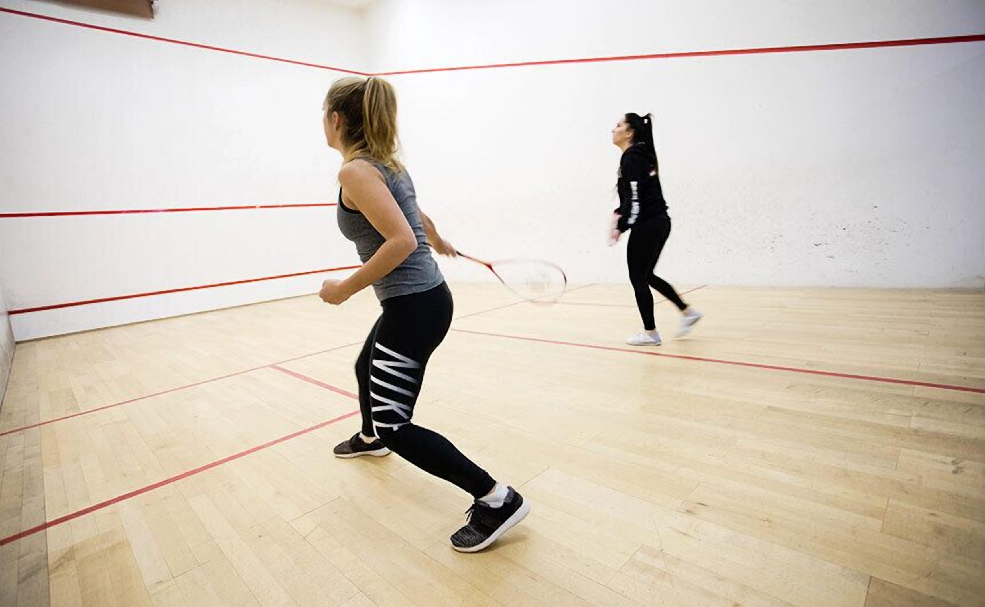 Ein Squashplatz mit Holzboden und roten Spielfeldmarkierungen.