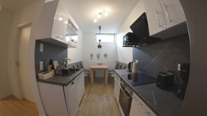 A compact kitchen with a dining area, equipped with modern appliances and a small window for natural light. - Schöne Groß Ferienwohnung 78m² Ideal für Familie 3 Schlafzimmer Zentrumnah 1.og (Erfurt)