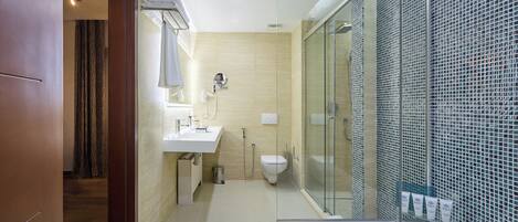 A modern bathroom with a glass shower enclosure, a white sink, and a bathtub.