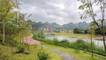 A river with a bridge, greenery, and a path.