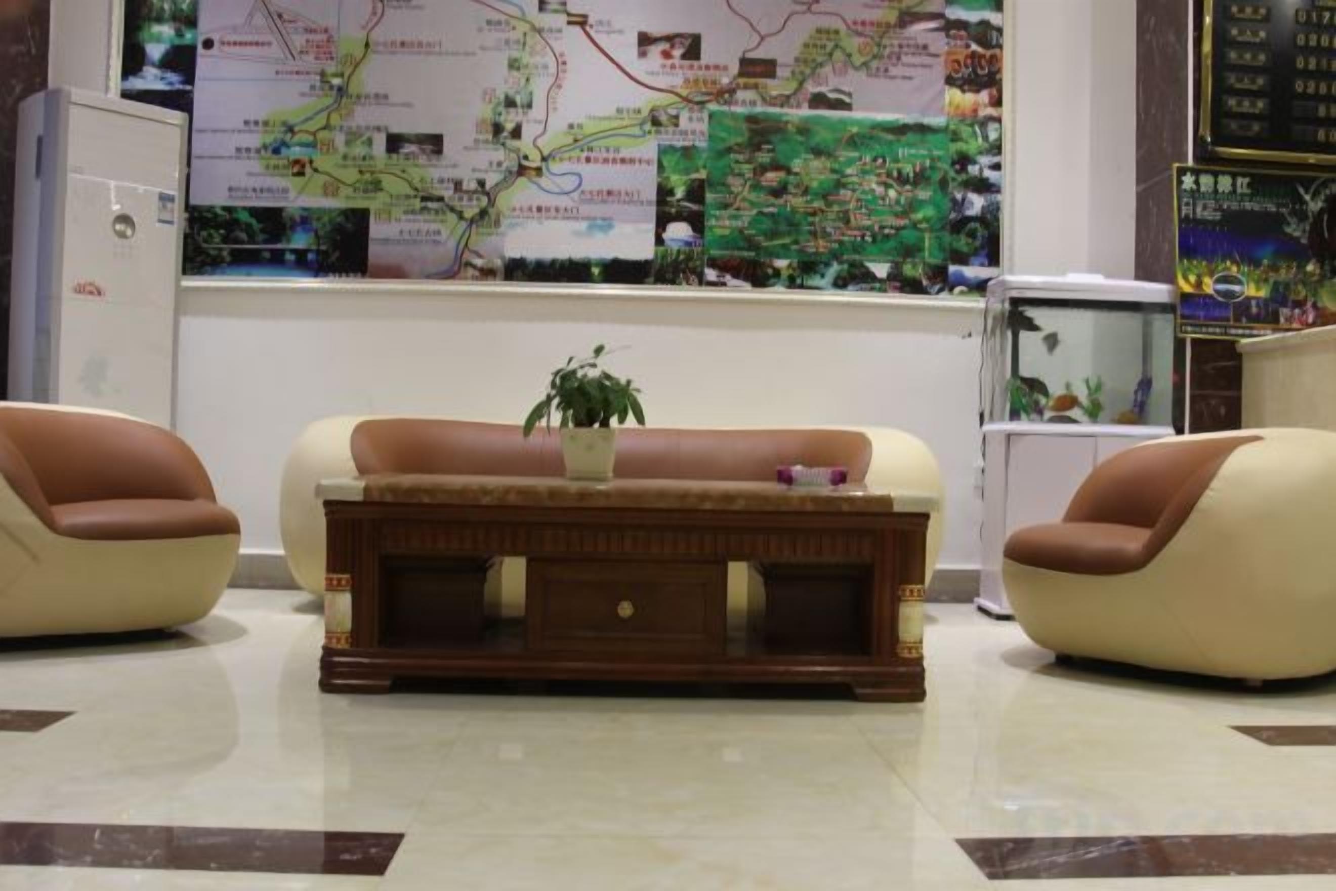 A lobby with a sofa set, a small table with a plant, and a fish tank.