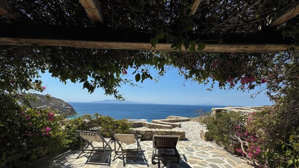 A stone pathway leading to a seating area with a view of the sea and mountains. - Elia Oasis 2 Bd Magic Villa w Sea Views (Mykonos)