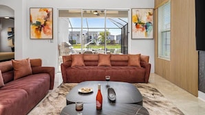 A modern living room with a sectional sofa, a coffee table, and abstract art on the walls.