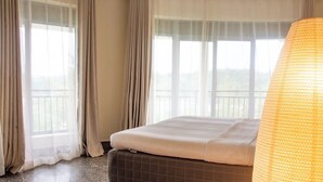 Une chambre d’hôtel avec un lit, des rideaux et une vue par la fenêtre.