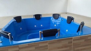 A blue hot tub with four black seats and chrome fixtures. - Balneario manantial  (San Pablo de Borbur)