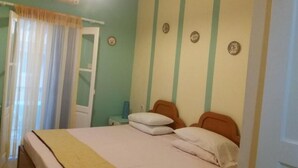 Un dormitorio con cama, cortinas, un reloj de pared y una puerta.