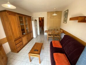 Ein kleiner Wohnbereich mit Küchenzeile, Essplatz und Sofa.