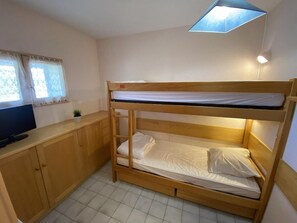A bunk bed with a TV on a wooden cabinet, a small plant, and a window with curtains. - Ski-in/ski-out & foot of the slopes, 8th floor, view ski slopes, balcony, parking, tv, 28m² (Le Dévoluy)