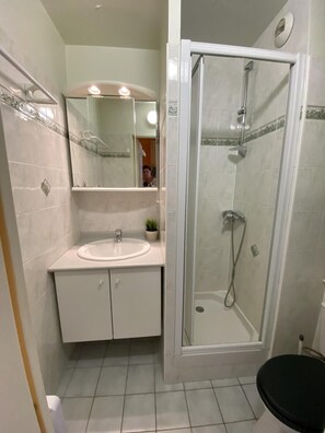 A bathroom with a white sink, a mirror, a shower enclosure, and a toilet. - Ski-in/ski-out & foot of the slopes, 8th floor, view ski slopes, balcony, parking, tv, 28m² (Le Dévoluy)