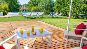 An outdoor patio with a pool, lounge chairs, and a table with drinks and snacks. - Villa Ambra by Villa Plus (San Vito dei Normanni)