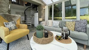 Una sala moderna con un sillón amarillo, un sofá gris y una mesa de centro con adornos.
