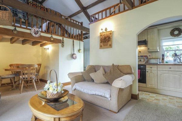 Nyth y Wennol sitting room leading to dining area with round table and four chairs
