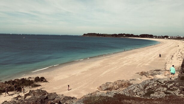 A beach with a rocky foreground, a sandy shore, and a calm sea. - Bel Appartement Familial en Duplex, à 2 min à Pied de la Plage (ARZON (56640))