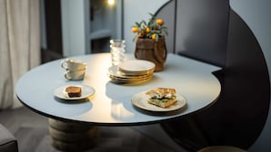 A round table with a dessert plate, a cup, a glass, and a plant.