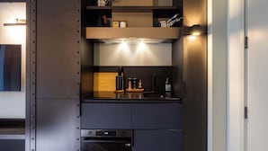 A modern kitchen with built-in appliances, wooden flooring, and a minimalist design.