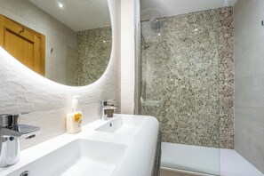 Chuveiro, secador de cabelo, toalhas de banho, papel higiênico