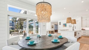 A modern kitchen with white cabinets, a central island, and pendant lighting. - Spacious Home w/ Pool & Short Trip to the Beach (Hilton Head Island)