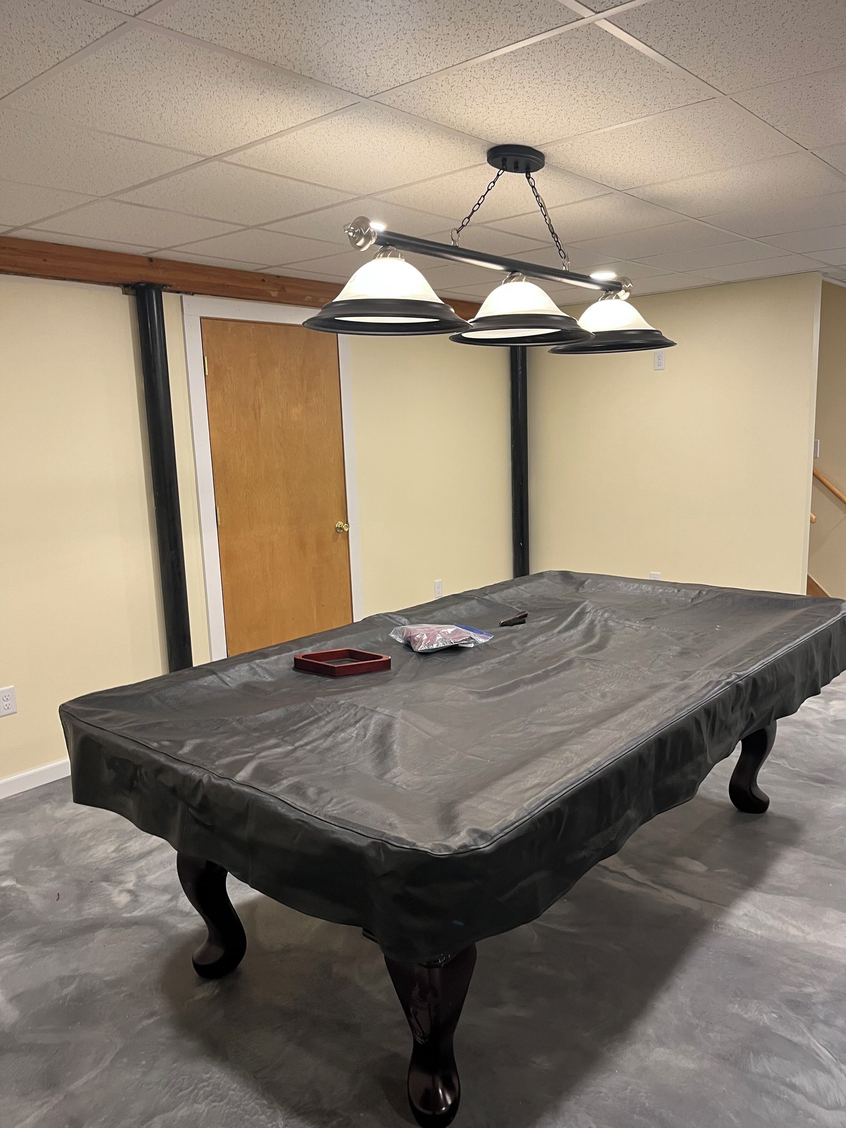 A conference room with a long table, black tablecloth, and three pendant lights.