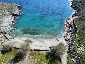 An aerial view of a coastal area with clear turquoise waters, rocky cliffs, and a sandy beach. - Seaside Bliss Tranquil Retreat on Kythnos Island (Kithnos)