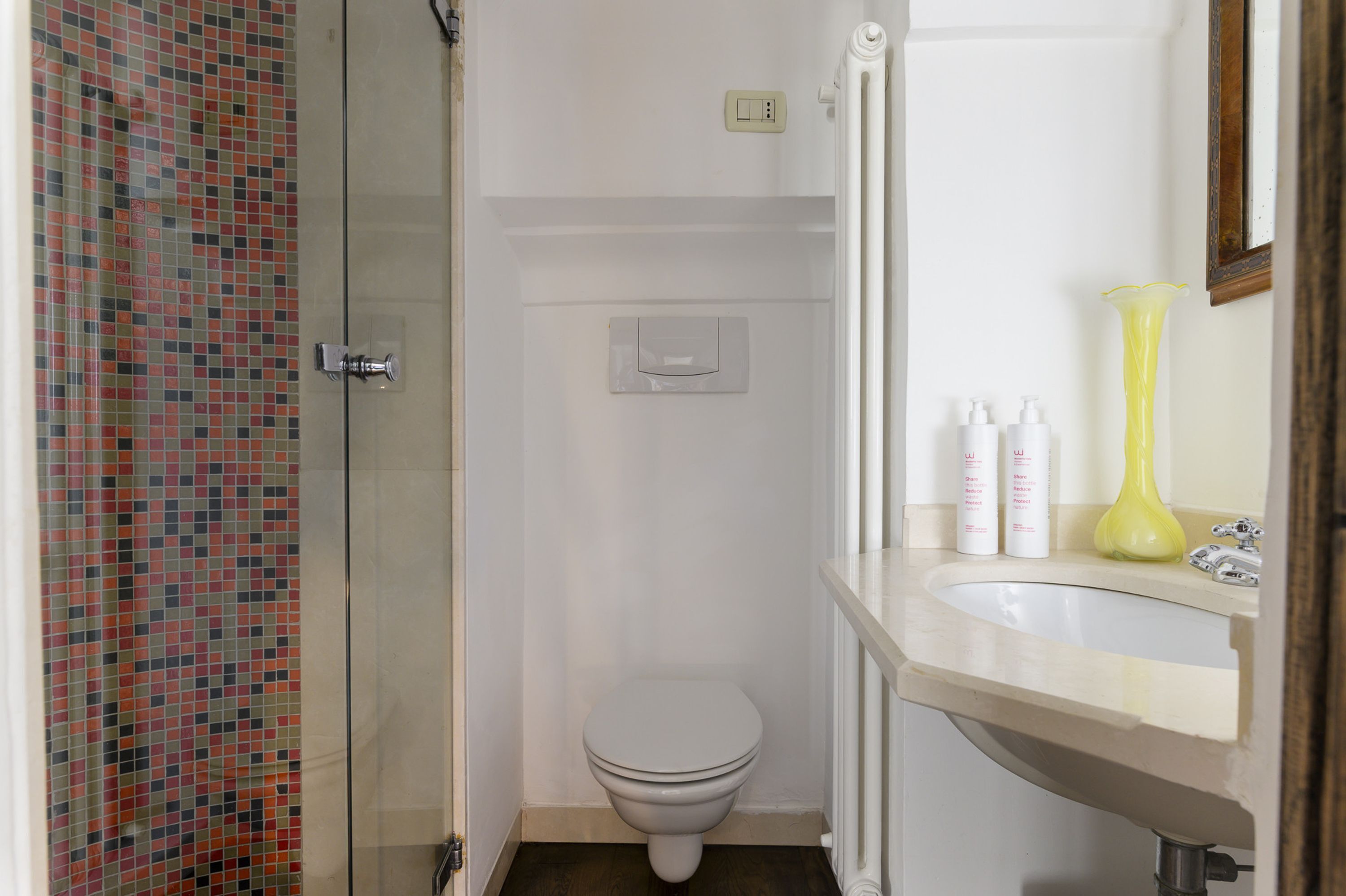 Un bagno con un water, una doccia e un lavandino.