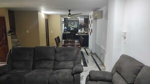 A living room with two sofas, a dining table, and a kitchen in the background. - Espectacular Casa - Hotel Boutique Cartagena - Barrio Castillogrande (Cartagena de Indias)