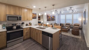 A modern kitchen with stainless steel appliances, wooden cabinets, and a central island. - Luxury Downtown 2 Bd 2 Ba Suite - Rooftop Terrace, Steps to Delta Center & More! (Salt Lake City)