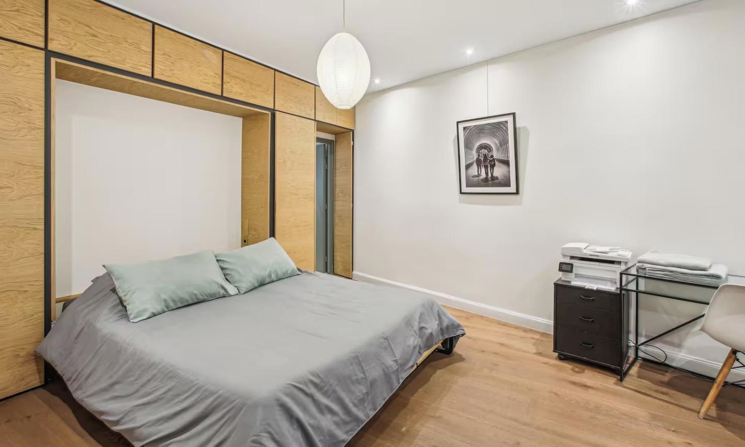 A bedroom with a bed, a desk, and a chair.