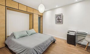 A bedroom with a bed, a desk, and a chair. - A DESIGNER PLACE WITH PRIVATE PATIO IN THE HEART OF SAINT GERMAIN - RUE CLEMENT (Paris)