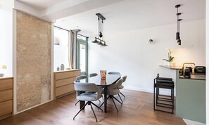 Une cuisine moderne avec un coin repas, des meubles en bois et un bar.