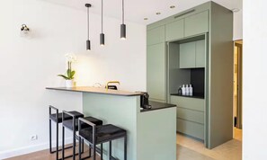 Eine moderne Küche mit Barbereich, Spüle und einer Arbeitsplatte mit Flaschen.