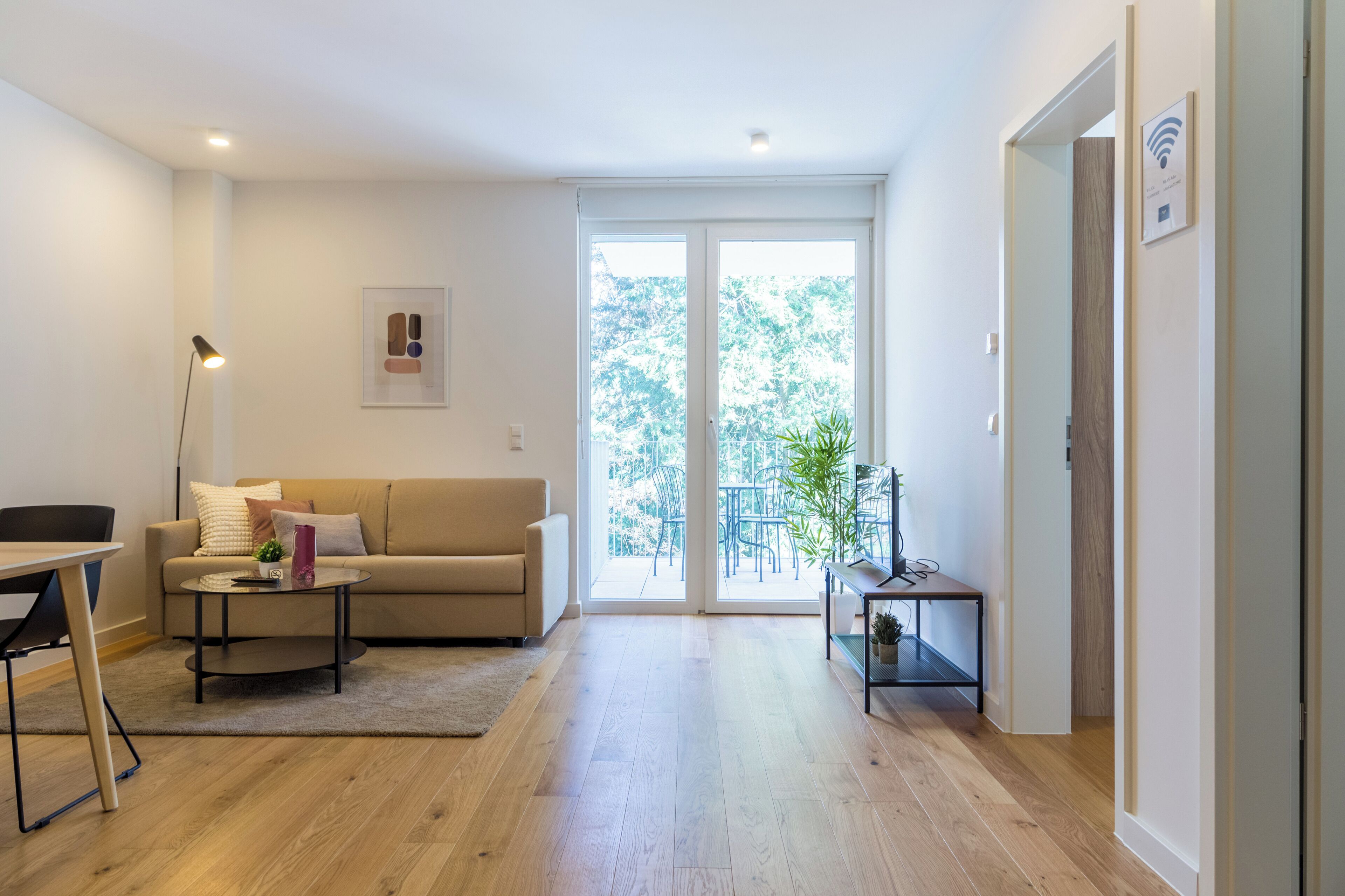 A modern living room with a sofa, coffee table, and a dining area.