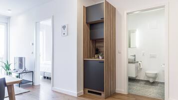 Eine moderne Wohnung mit einer Holzregal, einem Essbereich mit Tisch und Stühlen sowie einem Badezimmer mit Toilette und Waschbecken.