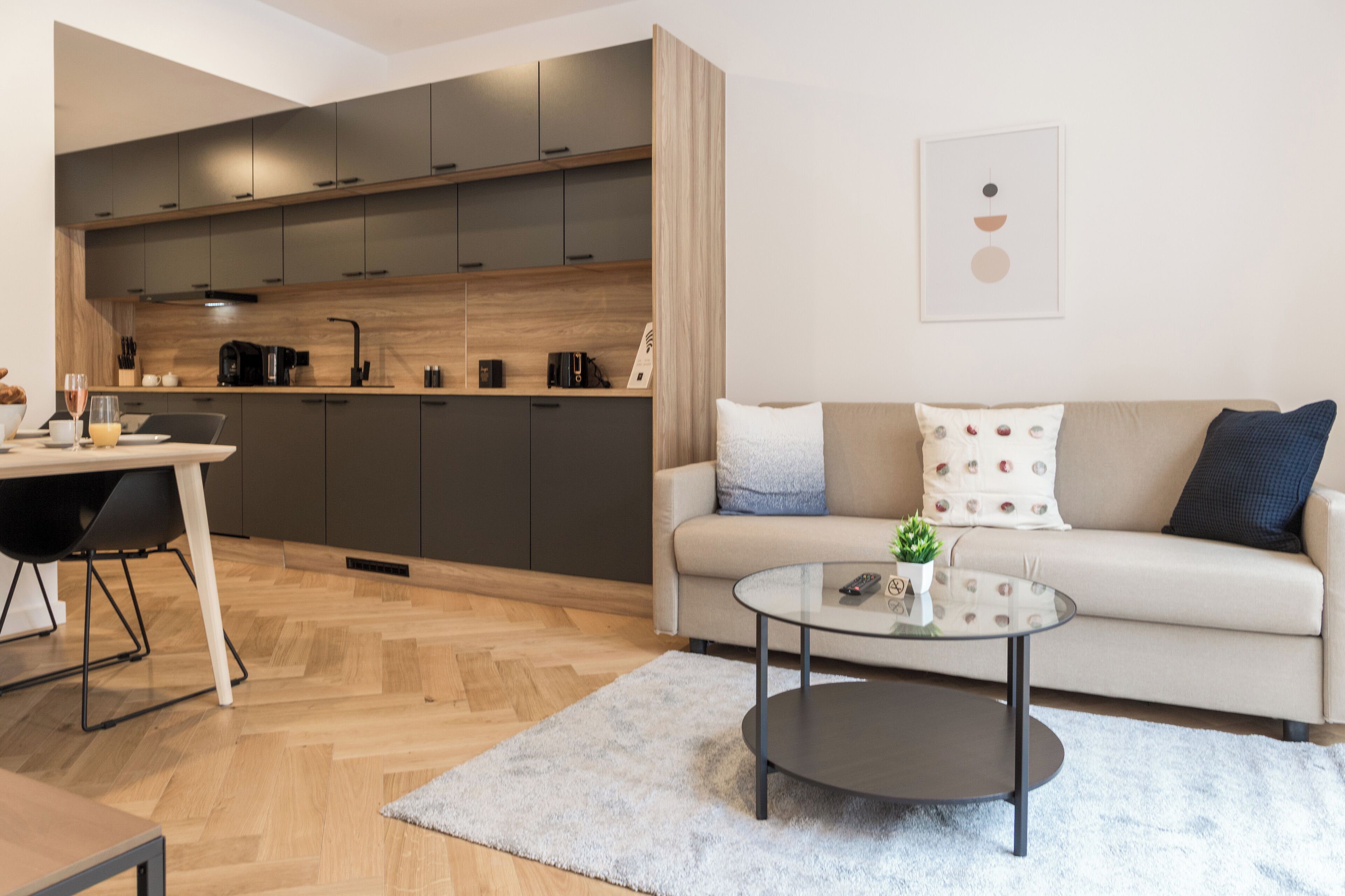 A modern living room with a sofa, coffee table, and kitchen area.