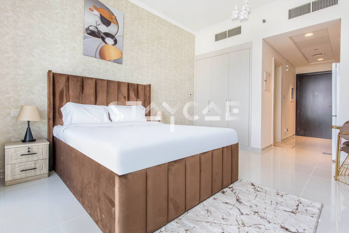 A modern bedroom with a wooden headboard bed, a marble-patterned rug, and a nightstand with a lamp.
