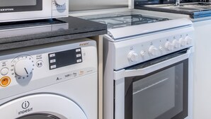 A modern kitchen with a washing machine, a microwave, and a stove. - Staycae Holiday Homes - Carson Tower (Dubai)
