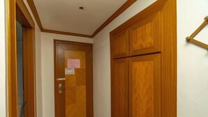 A hallway with wooden doors and a tiled floor. - Jinyuan Hostel (Yueqing)